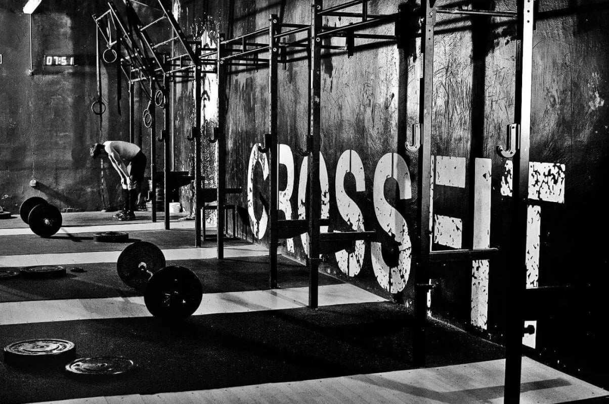 CrossFit gym met barbells en een uitgeputte sporter - for those who train with intention